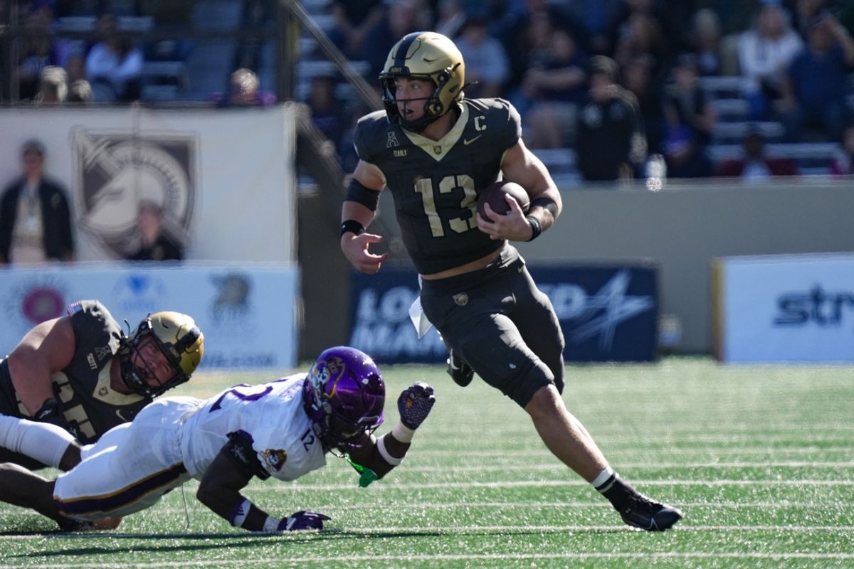 Oct 19, 2024; West Point, New York, USA; Army Black Knights quarterback Bryson Daily (13) evades a tackle from East Carolina Pirates defensive back Omar Rogers (12) during the second half at Michie Stadium. Mandatory Credit: Lucas Boland-Imagn Images