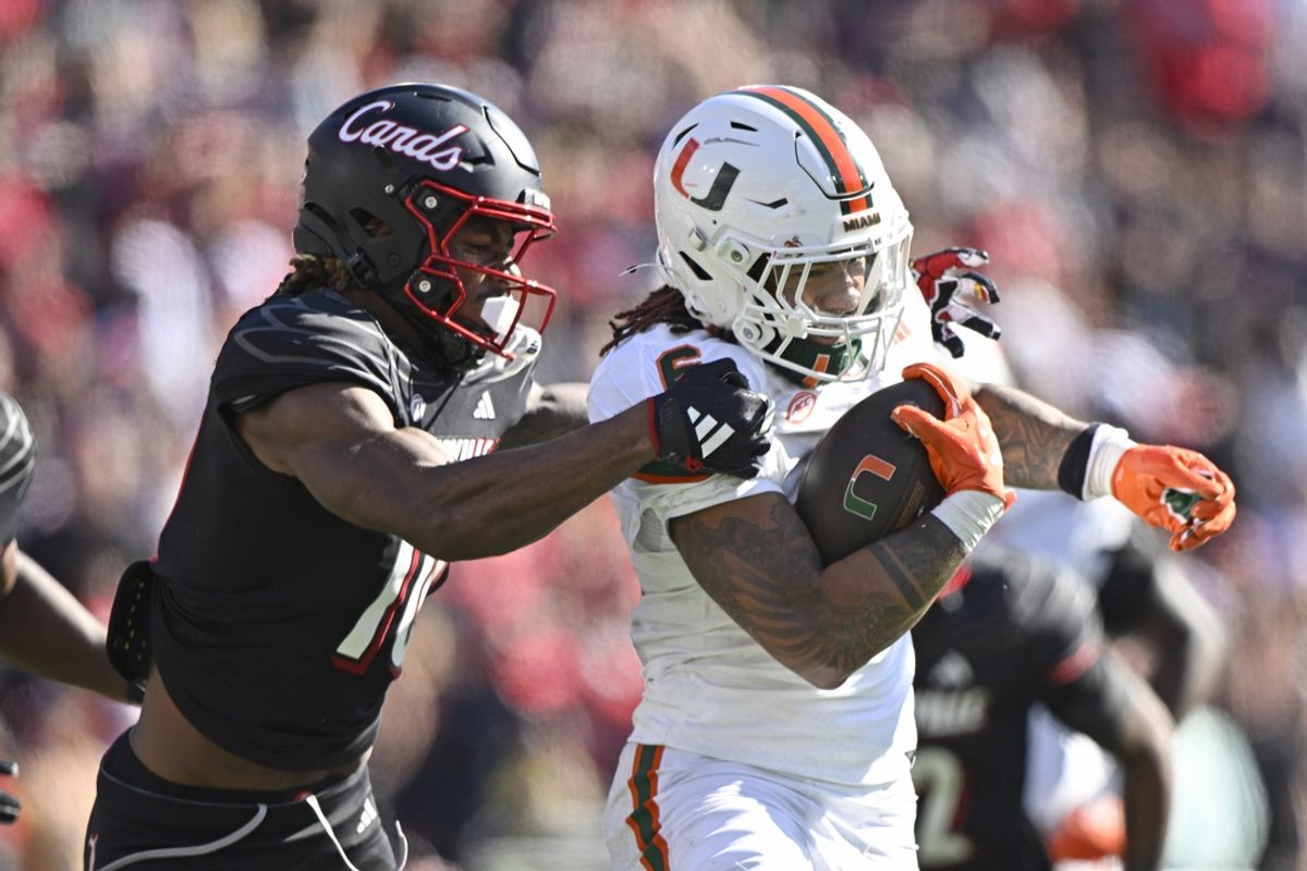 Oct 19, 2024; Louisville, Kentucky, USA; Miami Hurricanes running back Damien Martinez (6) runs the ball against Louisville Cardinals defensive back Benjamin Perry (10) during the second half at L&N Federal Credit Union Stadium. Miami defeated Louisville 52-45. Mandatory Credit: Jamie Rhodes-Imagn Images