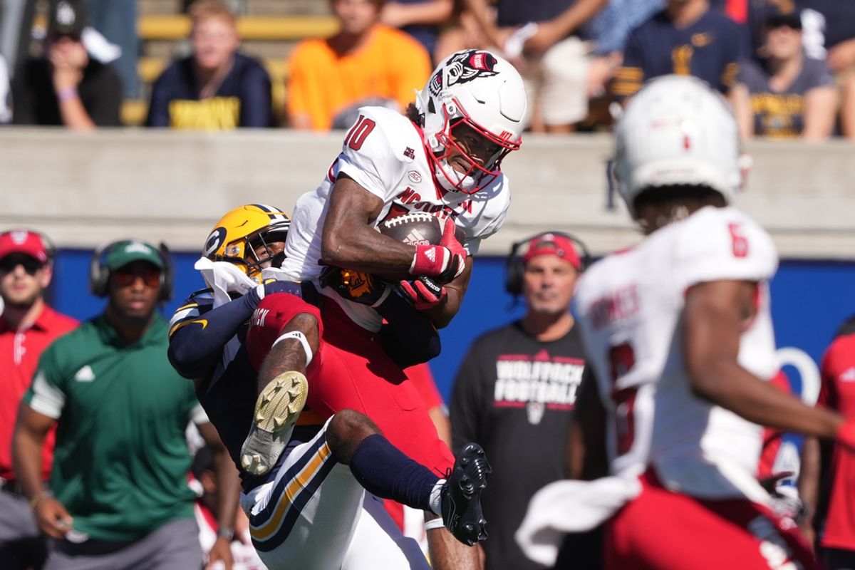 Oct 19, 2024; Berkeley, California, USA; North Carolina State Wolfpack wide receiver Kevin Concepcion (10) secures a catch against defensive back Craig Woodson (left) during the second quarter at California Memorial Stadium. Mandatory Credit: Darren Yamashita-Imagn Images