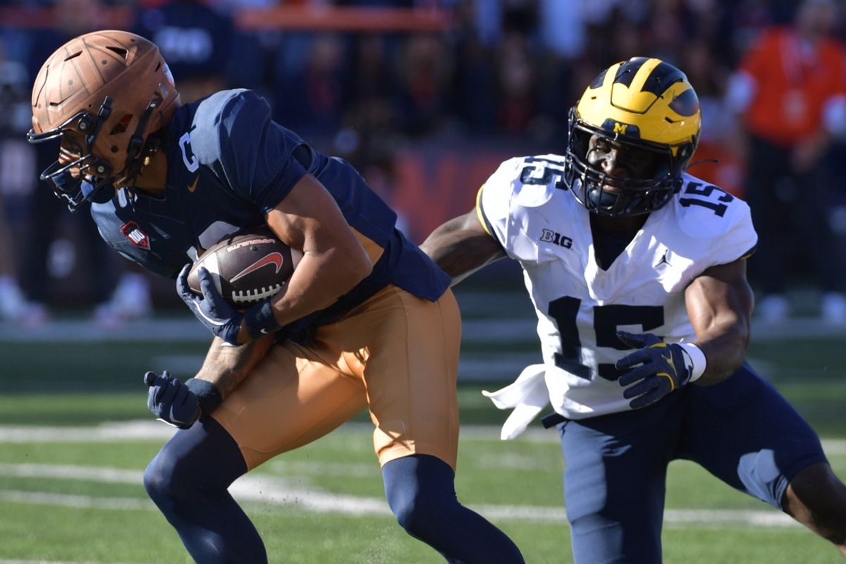 Oct 19, 2024; Champaign, Illinois, USA;  Illinois Fighting Illini wide receiver Pat Bryant (13) makes a short catch and run against Michigan Wolverines linebacker Ernest Hausmann (15) during the first half at Memorial Stadium. Mandatory Credit: Ron Johnson-Imagn Images