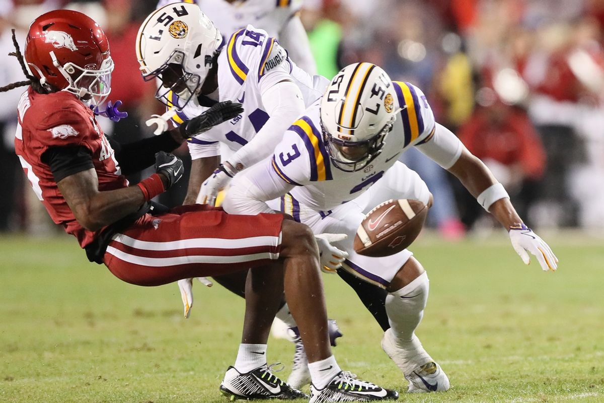 Oct 19, 2024; Fayetteville, Arkansas, USA; Arkansas Razorbacks wide receiver Tyrone Broken (5) attempts a catch as LSU Tigers cornerback Zy Alexander (14) and safety Sage Ryan (3) defend at Donald W. Reynolds Razorback Stadium. Mandatory Credit: Nelson Chenault-Imagn Images