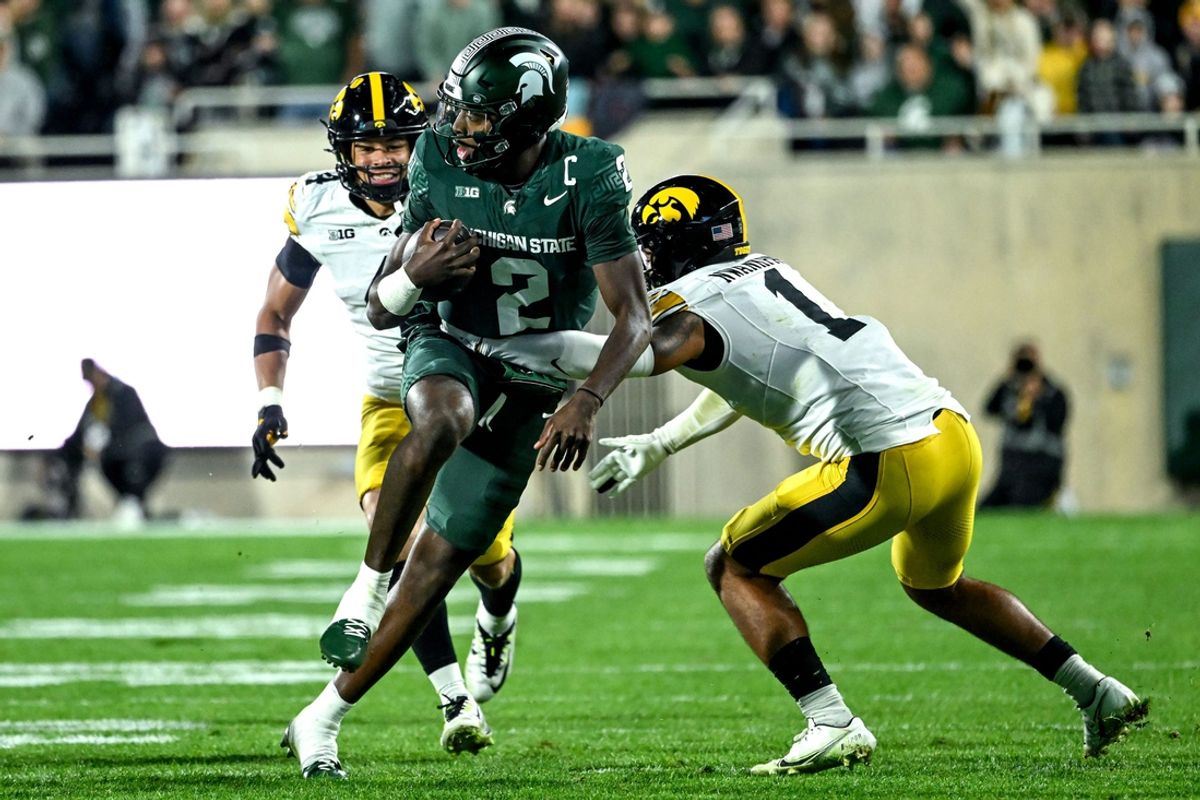Michigan State's Aidan Chiles, center, runs for a big gain as Iowa's Brendan Sullivan, right, attempts a tackle during the third quarter on Saturday, Oct. 19, 2024, at Spartan Stadium in East Lansing.