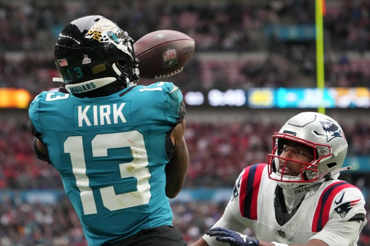 Oct 20, 2024; London, United Kingdom; Jacksonville Jaguars wide receiver Christian Kirk (13) attempts to catch the ball against New England Patriots cornerback Marcus Jones (25) in the second half of an NFL International Series game at Wembley Stadium. Mandatory Credit: Kirby Lee-Imagn Images