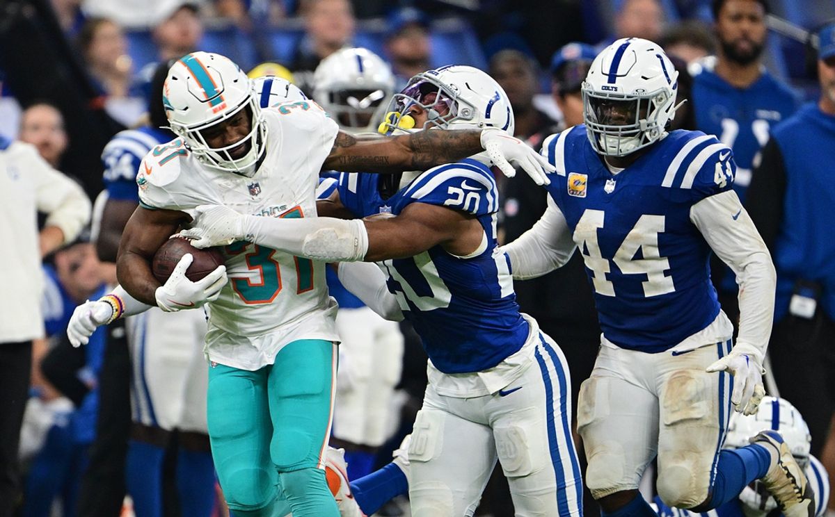 Oct 20, 2024; Indianapolis, Indiana, USA; Miami Dolphins running back Raheem Mostert (31) is tacked by Indianapolis Colts safety Nick Cross (20) during the second quarter at Lucas Oil Stadium. Mandatory Credit: Marc Lebryk-Imagn Images