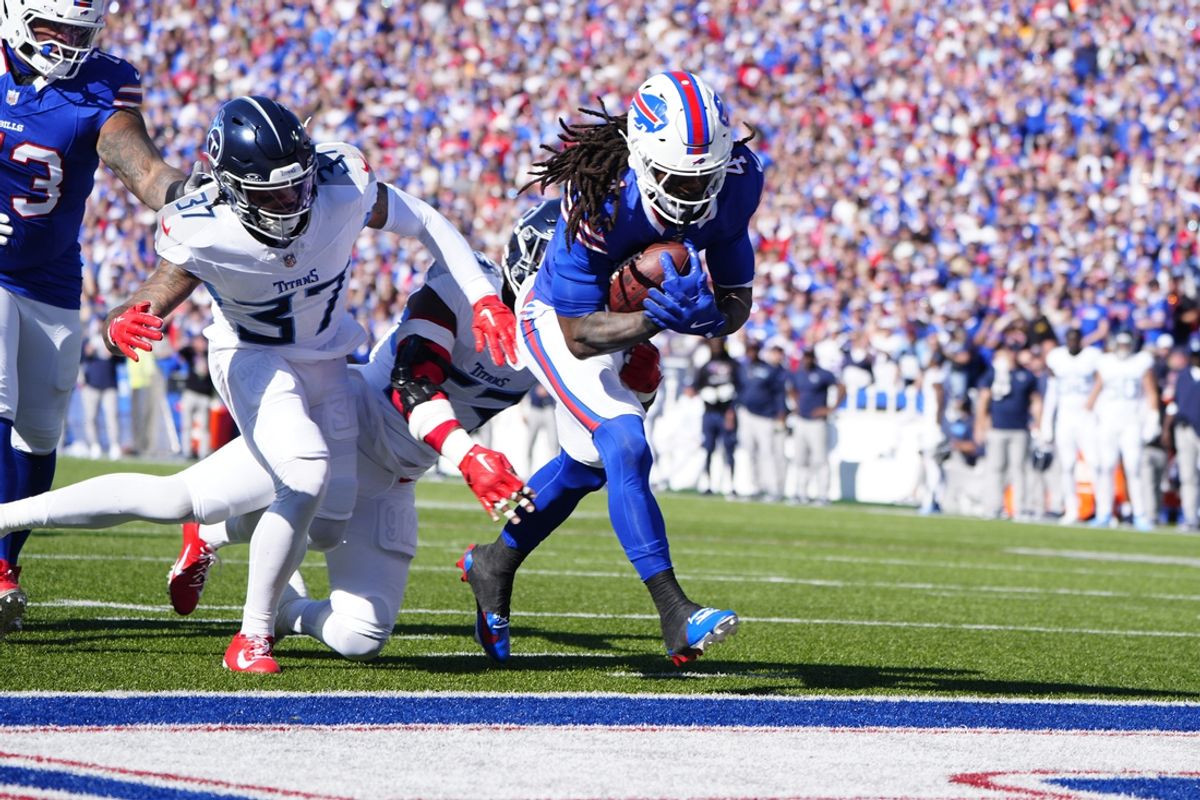Oct 20, 2024; Orchard Park, New York, USA; Buffalo Bills running back James Cook (4) runs with the ball for a touchdown against Tennessee Titans safety Amani Hooker (37) during the first half at Highmark Stadium. Mandatory Credit: Gregory Fisher-Imagn Images