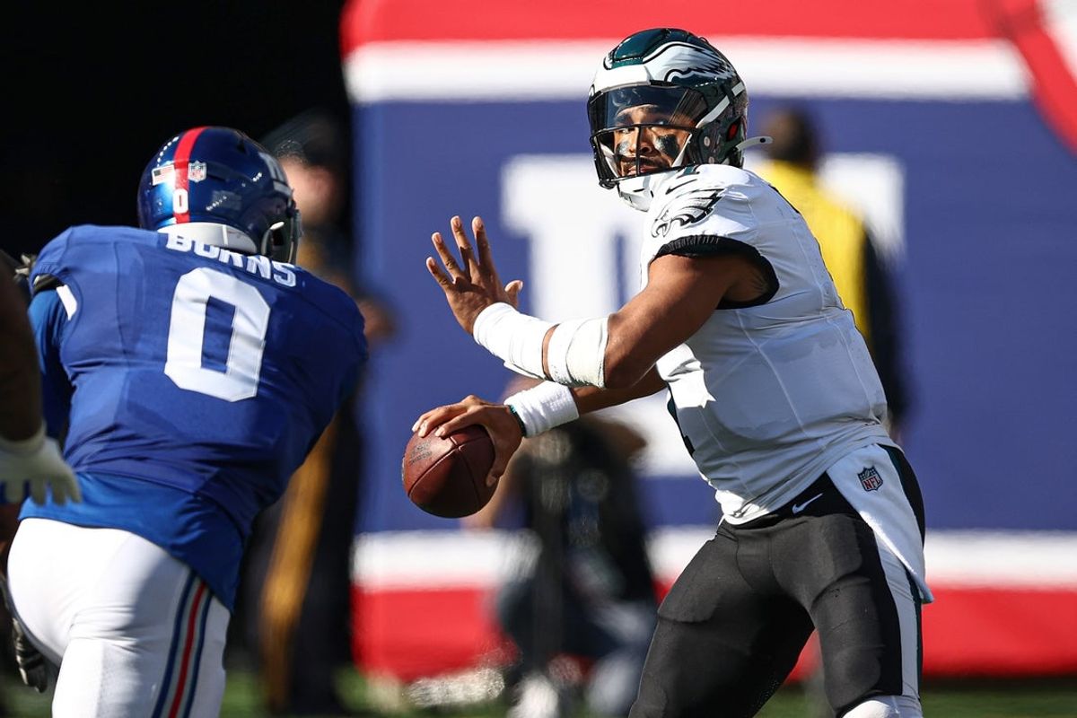 Philadelphia Eagles quarterback Jalen Hurts (1) throws the ball as New York Giants linebacker Brian Burns (0) pursues during the second half at MetLife Stadium. Mandatory Credit: Vincent Carchietta-Imagn Images