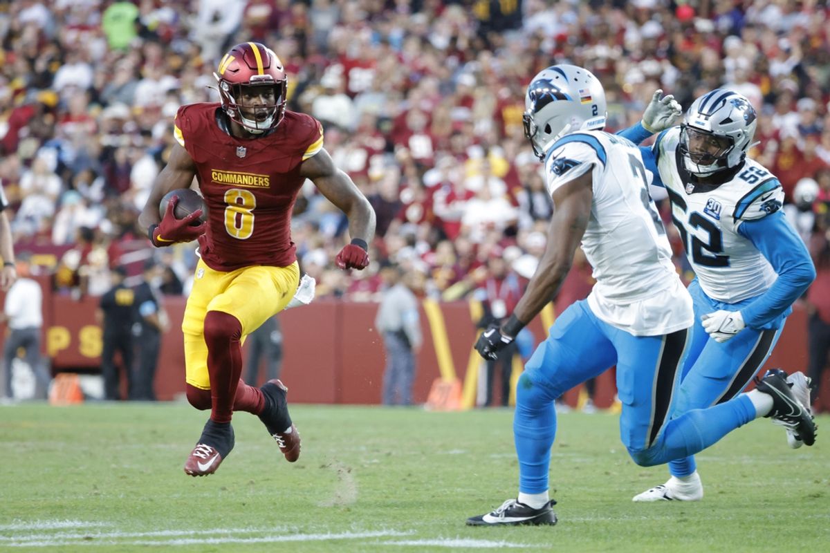 Oct 20, 2024; Landover, Maryland, USA; Washington Commanders running back Brian Robinson Jr. (8) carries the ball as Carolina Panthers cornerback Michael Jackson (2) and Panthers linebacker DJ Johnson (52) defends during the second half at Northwest Stadium. Mandatory Credit: Amber Searls-Imagn Images