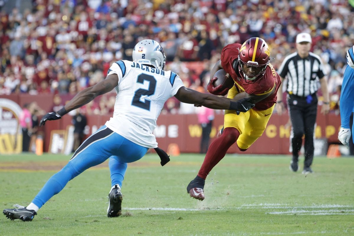 Oct 20, 2024; Landover, Maryland, USA; Washington Commanders running back Brian Robinson Jr. (8) carries the ball as Carolina Panthers cornerback Michael Jackson (2) defends during the second half at Northwest Stadium. Mandatory Credit: Amber Searls-Imagn Images