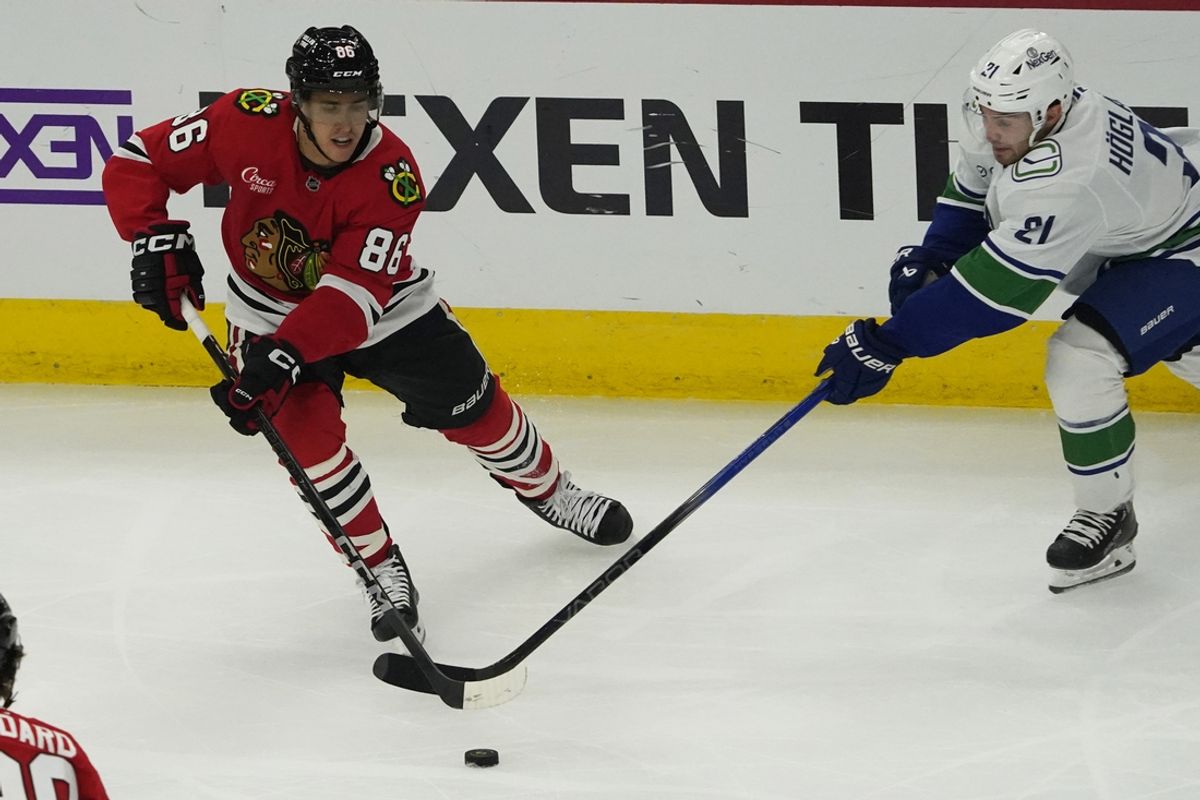 Oct 22, 2024; Chicago, Illinois, USA; Vancouver Canucks left wing Nils Hoglander (21) defends Chicago Blackhawks center Teuvo Teravainen (86) during the first period at United Center. Mandatory Credit: David Banks-Imagn Images