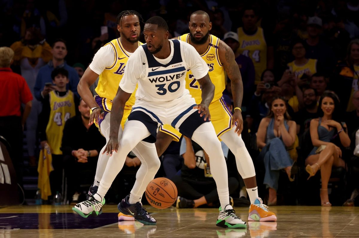 Oct 22, 2024; Los Angeles, California, USA; Los Angeles Lakers guard Bronny James (9) and forward LeBron James (23) guard Minnesota Timberwolves forward Julius Randle (30) during the second quarter against the Minnesota Timberwolves at Crypto.com Arena. This marked the first time in NBA history that a father and son played together. Mandatory Credit: Jason Parkhurst-Imagn Images