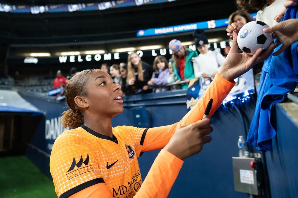 Oct 18, 2024; Seattle, Washington, USA;  Houston Dash midfielder Zoe Matthews (27) signs autographs for fans after a match against the Seattle Reign at Lumen Field. Mandatory Credit: Stephen Brashear-Imagn Images