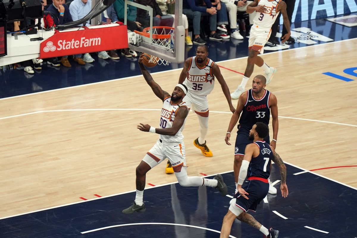 Oct 23, 2024; Inglewood, California, USA; Phoenix Suns forward Royce O'Neale (00) shoots the ball against LA Clippers guard Amir Coffey (7) and forward Nicolas Batum (33) in the first half at Intuit Dome. Mandatory Credit: Kirby Lee-Imagn Images