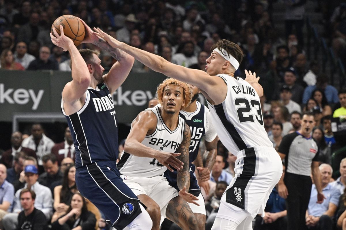 Oct 24, 2024; Dallas, Texas, USA; Dallas Mavericks guard Luka Doncic (77) looks to pass the ball by San Antonio Spurs forward Jeremy Sochan (10) and forward Zach Collins (23) during the second quarter at the American Airlines Center. Mandatory Credit: Jerome Miron-Imagn Images