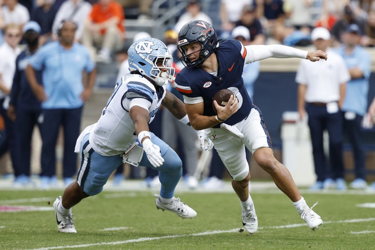 Oct 26, 2024; Charlottesville, Virginia, USA; Virginia Cavaliers quarterback Anthony Colandrea (10) scrambles from North Carolina Tar Heels linebacker Amare Campbell (17) during the first half at Scott Stadium. Mandatory Credit: Geoff Burke-Imagn Images