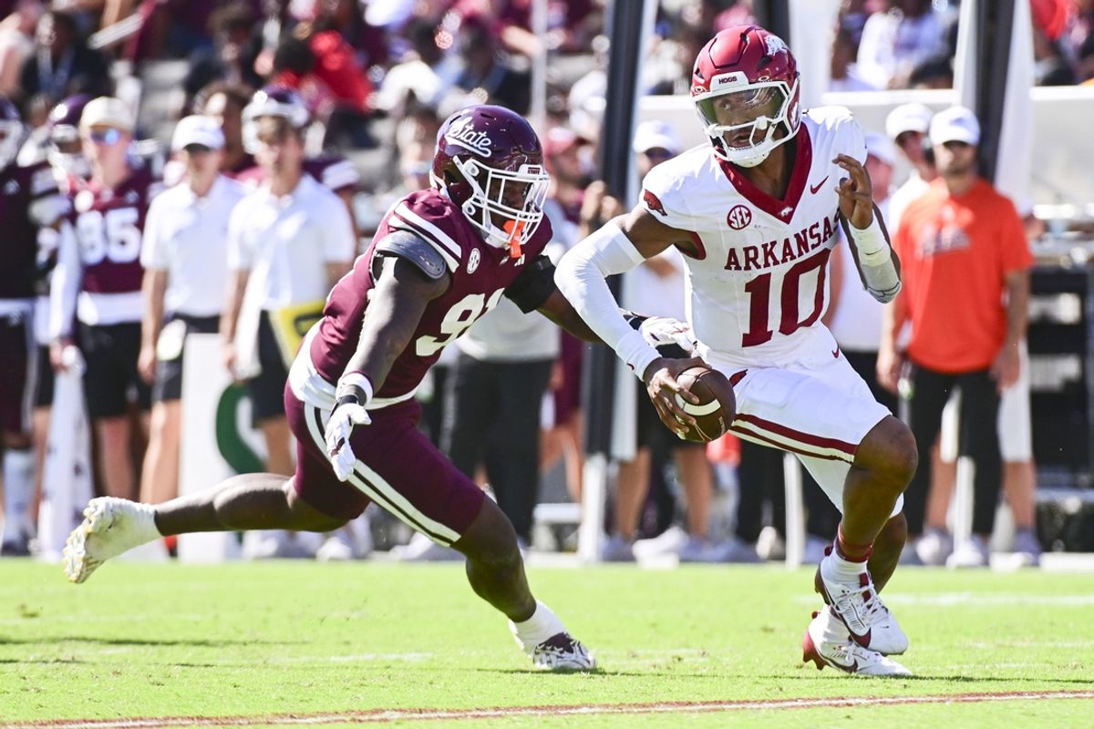 Oct 26, 2024; Starkville, Mississippi, USA; Arkansas Razorbacks quarterback Taylen Green (10) runs the ball while defended by Mississippi State Bulldogs defensive lineman Deonte Anderson (91) during the second quarter at Davis Wade Stadium at Scott Field. Mandatory Credit: Matt Bush-Imagn Images