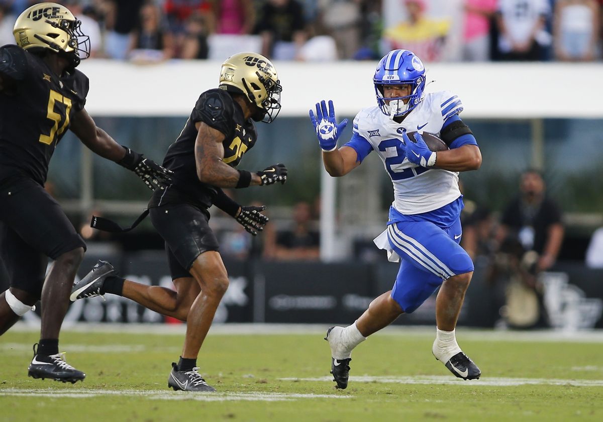 Oct 26, 2024; Orlando, Florida, USA;  Brigham Young Cougars running back LJ Martin (27) runs the ball against Central Florida Knights cornerback Chasen Johnson (27) in the second half at FBC Mortgage Stadium. Mandatory Credit: Russell Lansford-Imagn Images