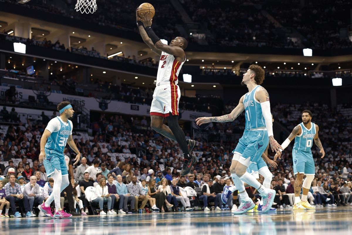 Oct 26, 2024; Charlotte, North Carolina, USA; Miami Heat guard Terry Rozier (2) drives the lane to the basket as Charlotte Hornets guards Seth Curry (30), LaMelo Ball (1) and forward Miles Bridges (0) look on during the first quarter at Spectrum Center. Mandatory Credit: Nell Redmond-Imagn Images
