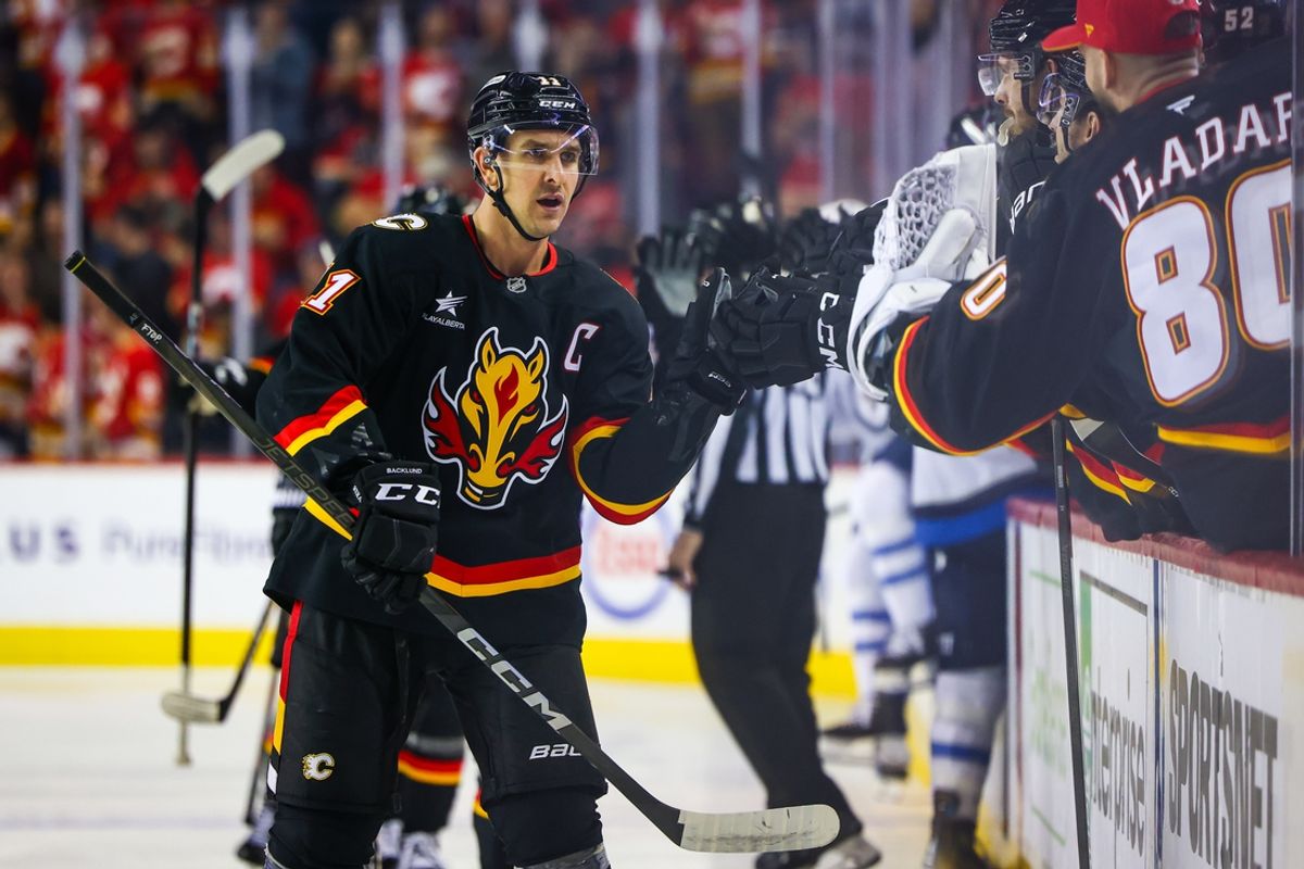 Oct 26, 2024; Calgary, Alberta, CAN; Calgary Flames center Mikael Backlund (11) celebrates his goal with teammates against the Winnipeg Jets during the first period at Scotiabank Saddledome. Mandatory Credit: Sergei Belski-Imagn Images