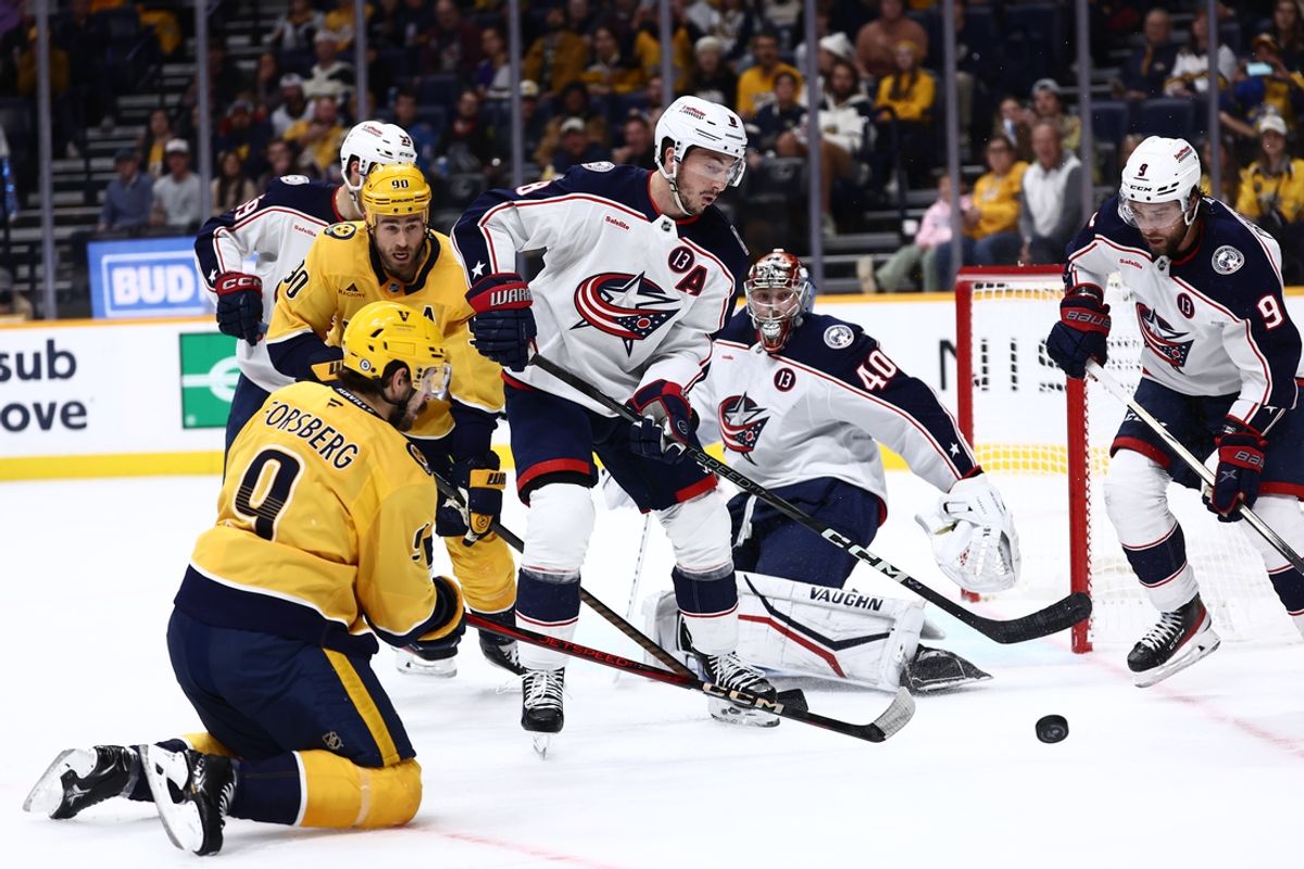 Oct 26, 2024; Nashville, Tennessee, USA; Columbus Blue Jackets defenseman Zach Werenski (8) and defenseman Ivan Provorov (9) defend the net from a shot on goal by Nashville Predators left wing Filip Forsberg (9) late in the first period at Bridgestone Arena. Mandatory Credit: Casey Gower-Imagn Images