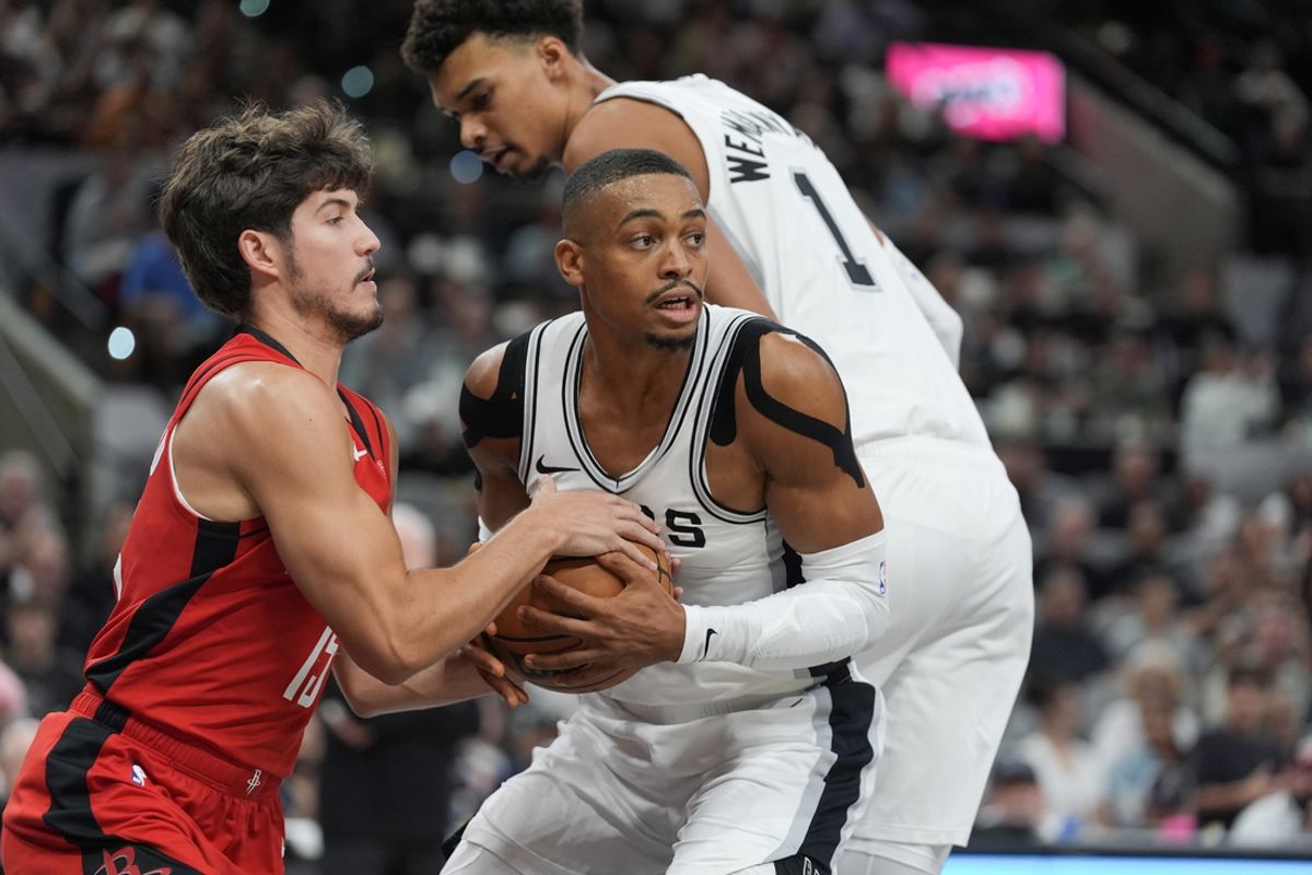 Oct 26, 2024; San Antonio, Texas, USA;  San Antonio Spurs forward Keldon Johnson (0) rebounds the ball from Houston Rockets guard Reed Sheppard (15) in the first half at Frost Bank Center. Mandatory Credit: Daniel Dunn-Imagn Images