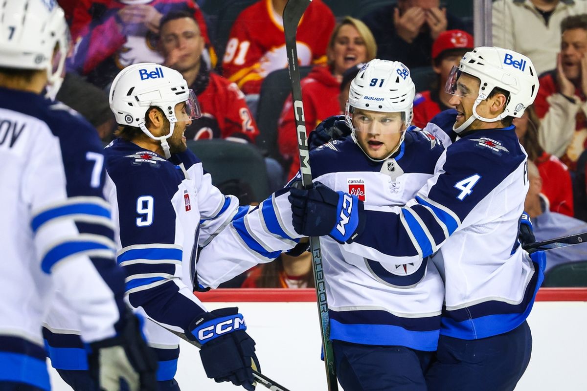 Oct 26, 2024; Calgary, Alberta, CAN; Winnipeg Jets center Cole Perfetti (91) celebrates his goal with teammates against the Calgary Flames during the third period at Scotiabank Saddledome. Mandatory Credit: Sergei Belski-Imagn Images