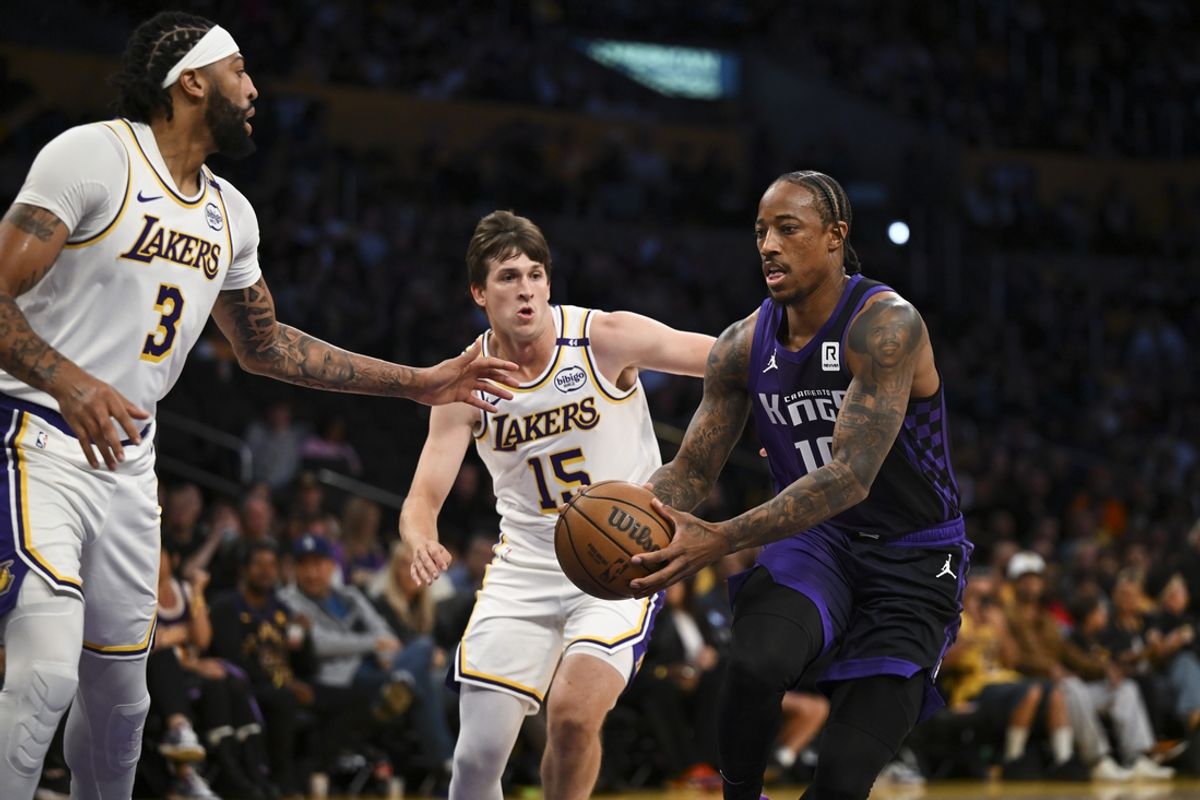 Oct 26, 2024; Los Angeles, California, USA; Sacramento Kings forward DeMar DeRozan (10) drives the ball against Los Angeles Lakers guard Austin Reaves (15) and forward Anthony Davis (3) during the first half at Crypto.com Arena. Mandatory Credit: Jonathan Hui-Imagn Images