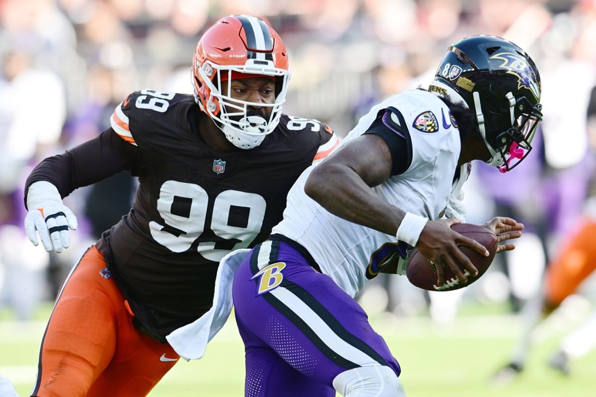 Oct 27, 2024; Cleveland, Ohio, USA; Cleveland Browns defensive end Za'Darius Smith (99) sacks Baltimore Ravens quarterback Lamar Jackson (8) during the second half at Huntington Bank Field. Mandatory Credit: Ken Blaze-Imagn Images