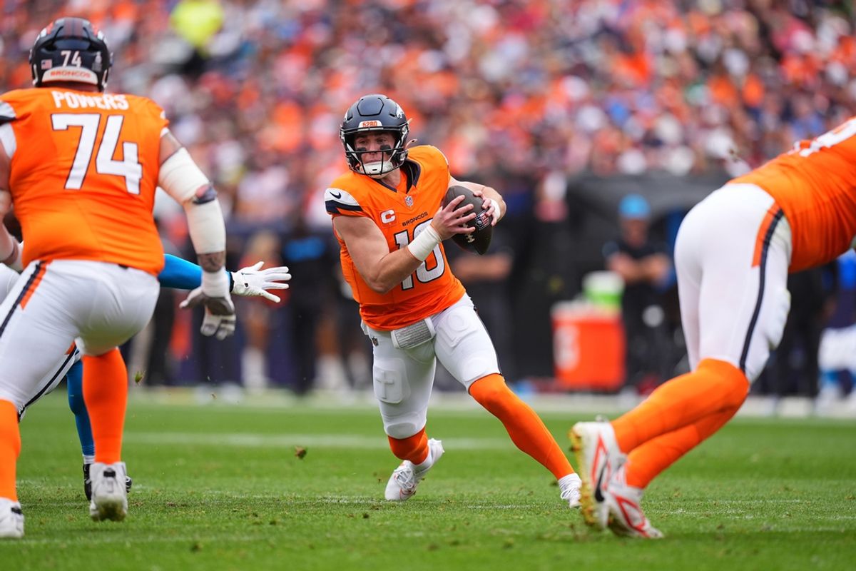 Oct 27, 2024; Denver, Colorado, USA; Denver Broncos quarterback Bo Nix (10) scrambles with the ball in the first half against the Carolina Panthers at Empower Field at Mile High. Mandatory Credit: Ron Chenoy-Imagn Images