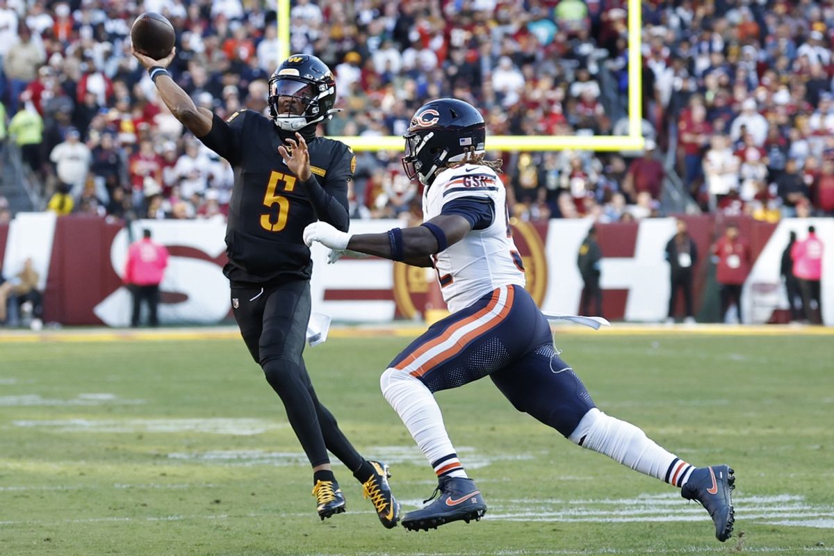 Oct 27, 2024; Landover, Maryland, USA; Washington Commanders quarterback Jayden Daniels (5) passes the ball as Chicago Bears defensive end Darrell Taylor (52) chases during the first quarter at Northwest Stadium. Mandatory Credit: Geoff Burke-Imagn Images