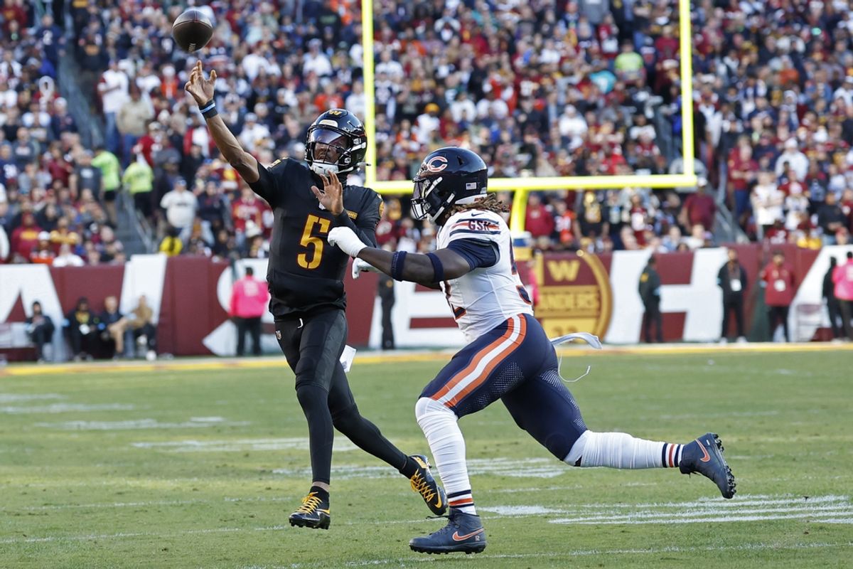Oct 27, 2024; Landover, Maryland, USA; Washington Commanders quarterback Jayden Daniels (5) passes the ball as Chicago Bears defensive end Darrell Taylor (52) chases during the first quarter at Northwest Stadium. Mandatory Credit: Geoff Burke-Imagn Images