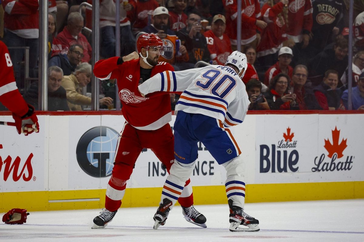 Oct 27, 2024; Detroit, Michigan, USA; Detroit Red Wings center Joe Veleno (90) fights with Edmonton Oilers right wing Corey Perry (90) during the first period of the game at Little Caesars Arena. Mandatory Credit: Brian Bradshaw Sevald-Imagn Images