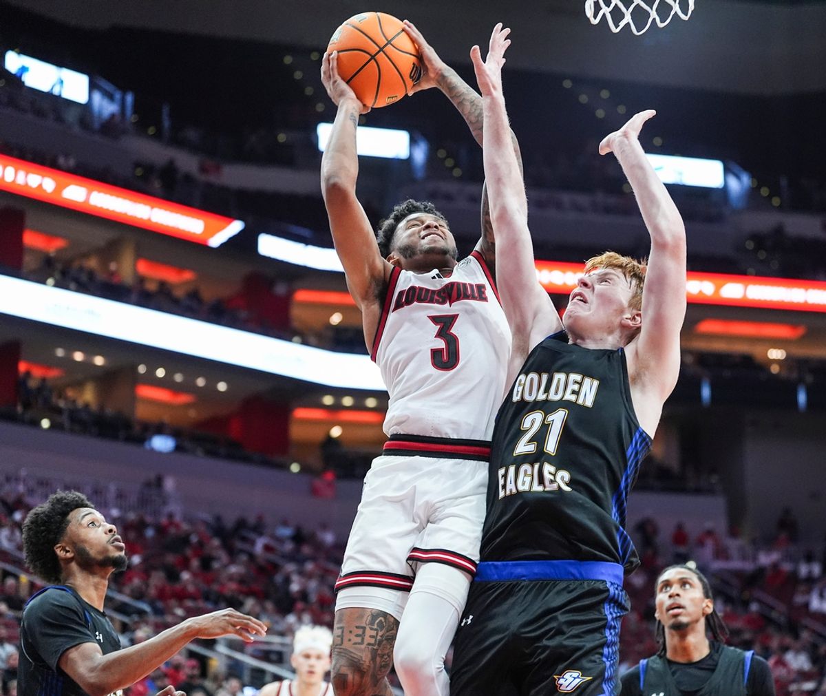 Louisville Cardinals guard Koren Johnson (3) gets two plus the foul against Spalding University's Levi Langley (21) in the second half in the Cards' second exhibition game against Spalding University at the KFC Yum! Center in Louisville, Kentucky Monday, Oct. 28, 2024.