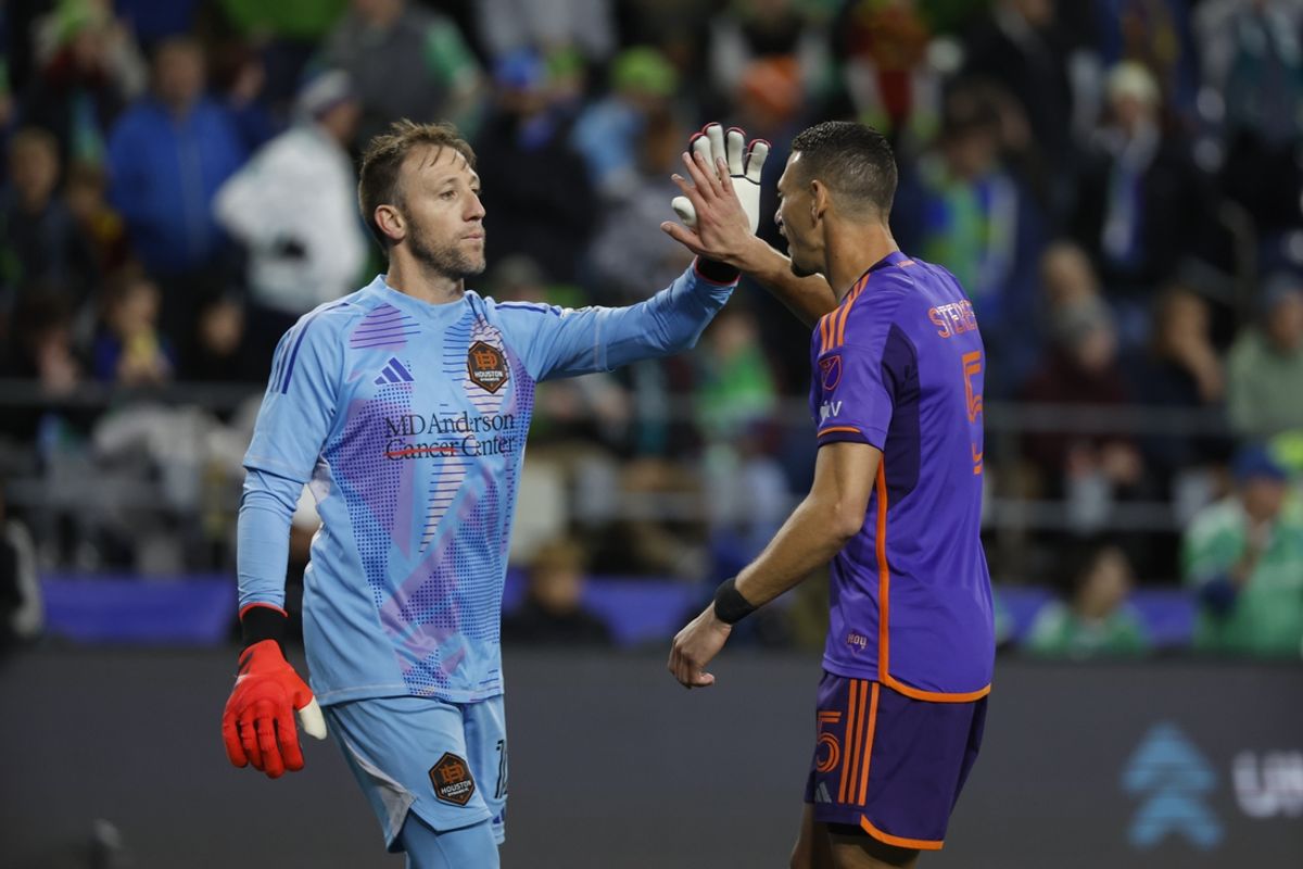 Oct 28, 2024; Seattle, Washington, USA; Houston Dynamo FC goalkeeper Steve Clark (12) high fives defender Daniel Steres (5) during a round of penalty kicks against the Seattle Sounders FC in a 2024 MLS Cup Playoffs Round One match at Lumen Field. Mandatory Credit: Joe Nicholson-Imagn Images