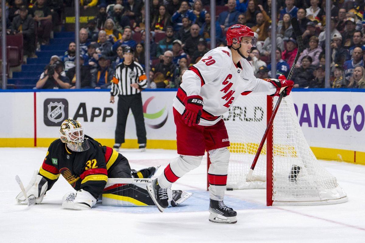 Oct 28, 2024; Vancouver, British Columbia, CAN; Carolina Hurricanes forward Sebastian Aho (20) scores the game winning goal on Vancouver Canucks goalie Kevin Lankinen (32) in overtime at Rogers Arena. Mandatory Credit: Bob Frid-Imagn Images