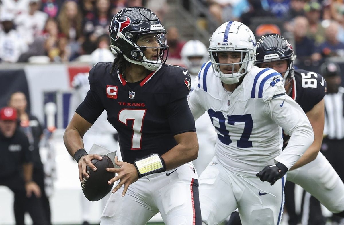 Houston Texans quarterback C.J. Stroud (7) looks for an open receiver as Indianapolis Colts defensive end Laiatu Latu (97) applies defensive pressure during the game at NRG Stadium. Mandatory Credit: Troy Taormina-Imagn Images