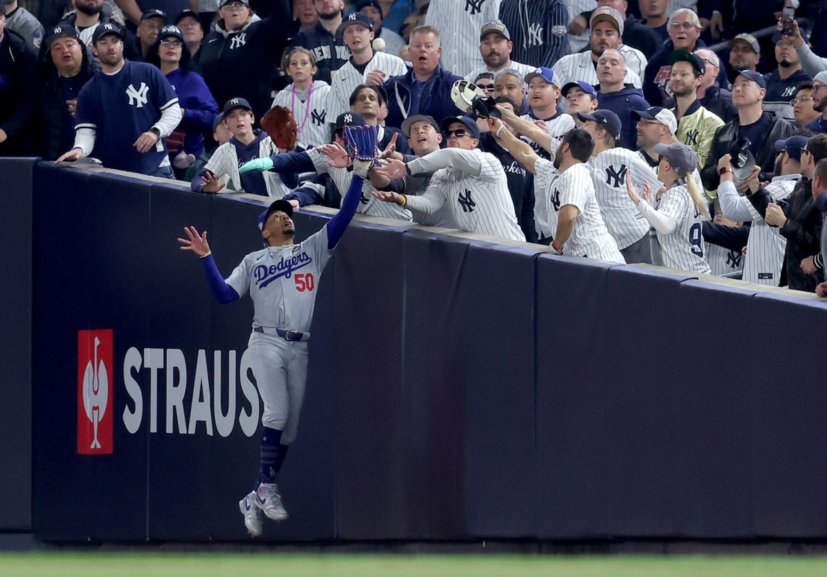 Oct 29, 2024; New York, New York, USA; Los Angeles Dodgers shortstop Mookie Betts (50) makes a catch in foul territory as a New York Yankees fan interferes during the first inning in game four of the 2024 MLB World Series at Yankee Stadium. Mandatory Credit: Brad Penner-Imagn Images