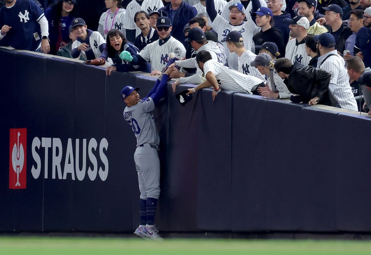 Oct 29, 2024; New York, New York, USA; Los Angeles Dodgers shortstop Mookie Betts (50) makes a catch in foul territory as a New York Yankees fan interferes during the first inning in game four of the 2024 MLB World Series at Yankee Stadium. Mandatory Credit: Brad Penner-Imagn Images