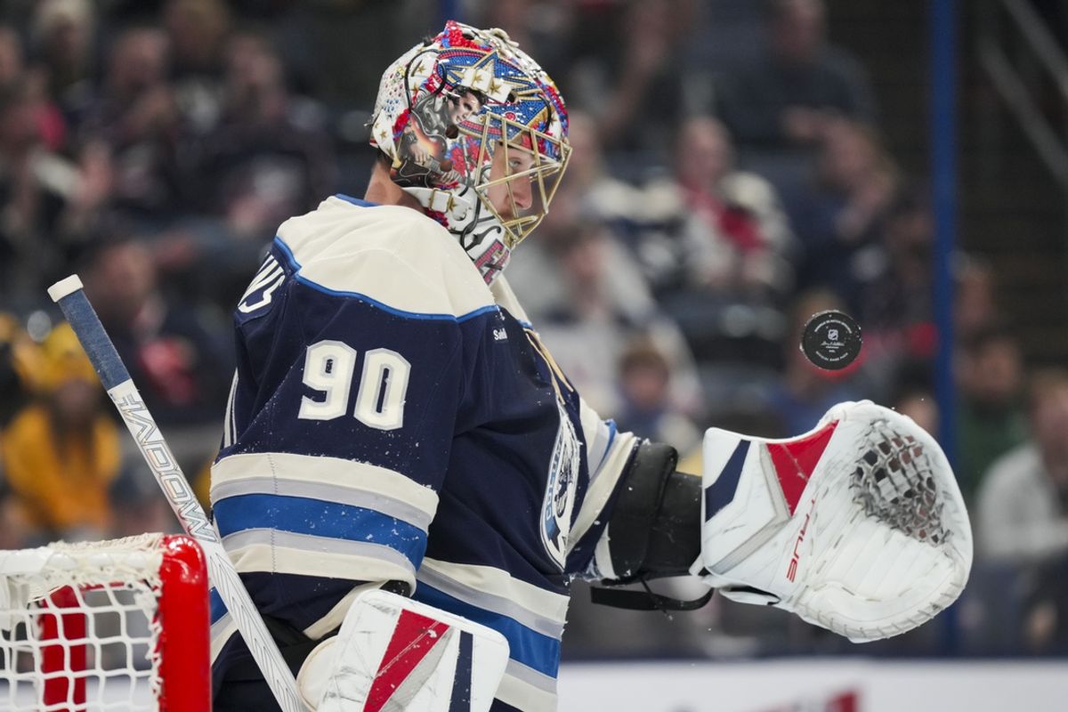 Oct 30, 2024; Columbus, Ohio, USA; Columbus Blue Jackets goaltender Elvis Merzlikins (90 flips the puck after making a save against the New York Islanders in the first period at Nationwide Arena. Mandatory Credit: Aaron Doster-Imagn Images