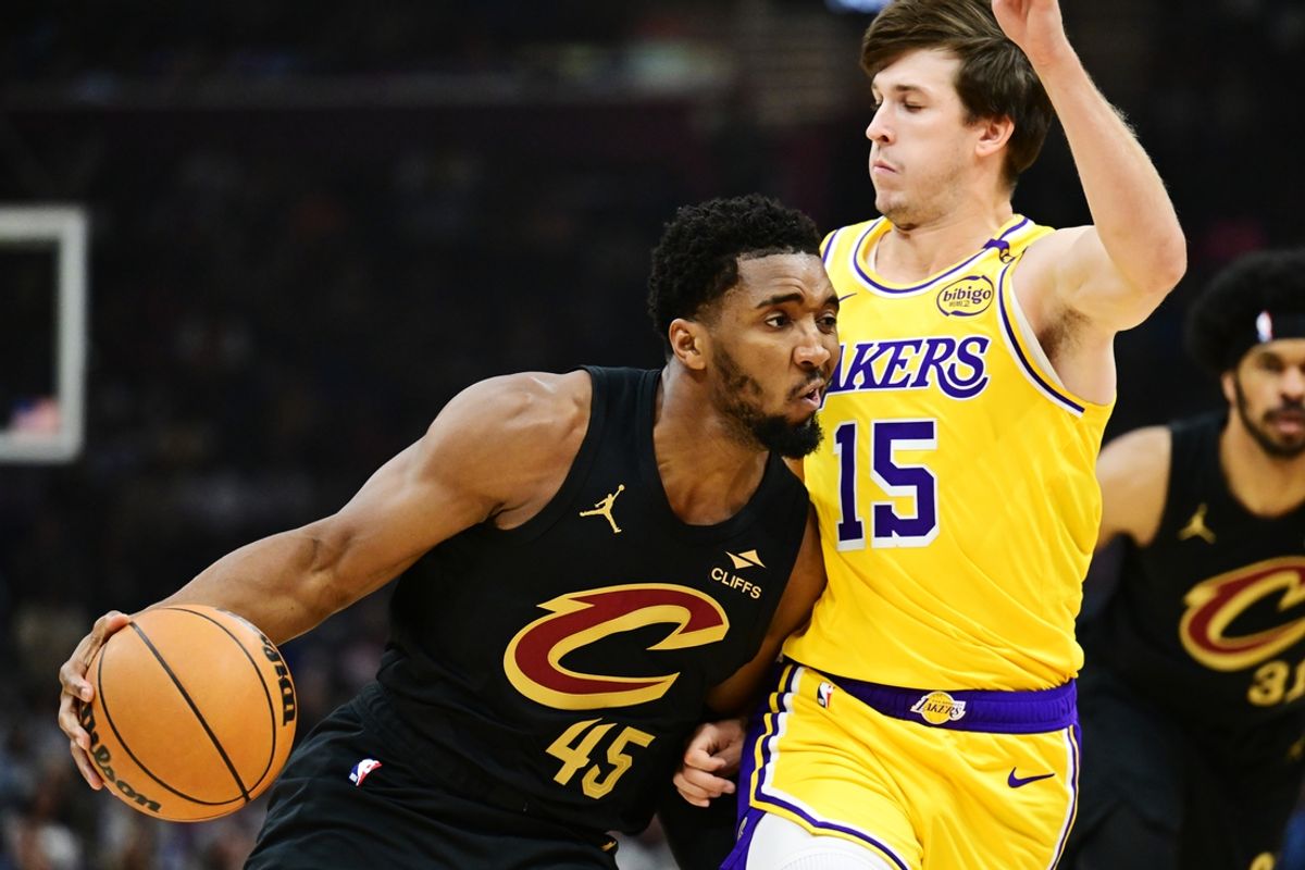 Oct 30, 2024; Cleveland, Ohio, USA; Cleveland Cavaliers guard Donovan Mitchell (45) drives to the basket against Los Angeles Lakers guard Austin Reaves (15) during the first quarter at Rocket Mortgage FieldHouse. Mandatory Credit: Ken Blaze-Imagn Images