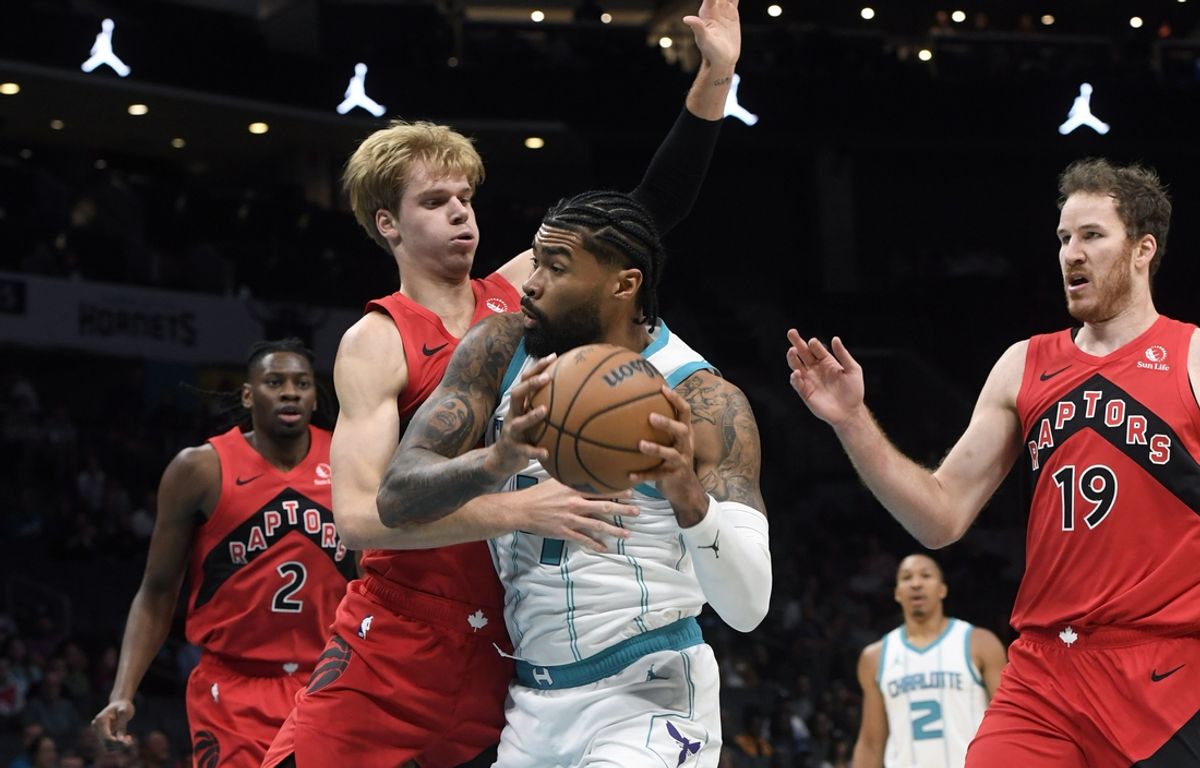 Oct 30, 2024; Charlotte, North Carolina, USA; Charlotte Hornets center Nick Richards (4) drives past Toront Raptors guard forward Gradey Dick (1) during the first half at the Spectrum Center. Mandatory Credit: Sam Sharpe-Imagn Images