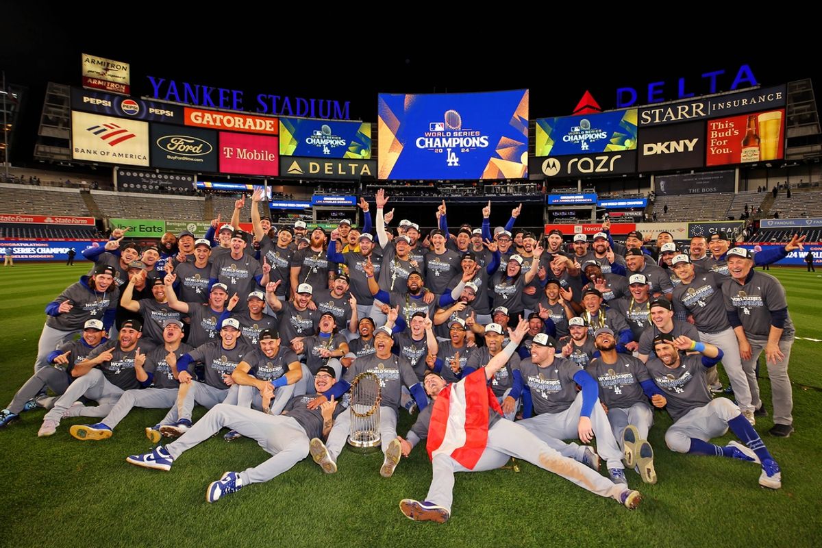 Oct 31, 2024; New York, New York, USA; The Los Angeles Dodgers pose for a picture with the Commissioner’s Trophy after beating the New York Yankees in game four to win the 2024 MLB World Series at Yankee Stadium. Mandatory Credit: Brad Penner-Imagn Images