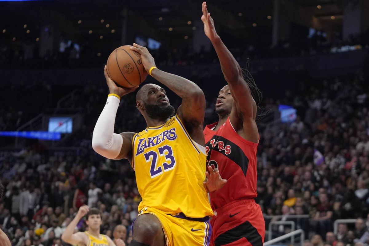 Nov 1, 2024; Toronto, Ontario, CAN; Los Angeles Lakers forward LeBron James (23) goes up to make a basket as Toronto Raptors forward Jonathan Mogbo (2) defends during the first half at Scotiabank Arena. Mandatory Credit: John E. Sokolowski-Imagn Images