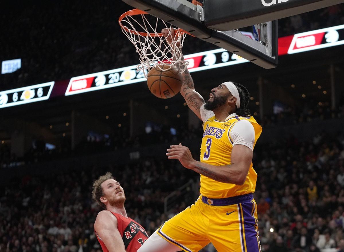 Nov 1, 2024; Toronto, Ontario, CAN; Los Angeles Lakers forward Anthony Davis (3) scores a basket as Toronto Raptors center Jakob Poeltl (19) looks on during the first half at Scotiabank Arena. Mandatory Credit: John E. Sokolowski-Imagn Images