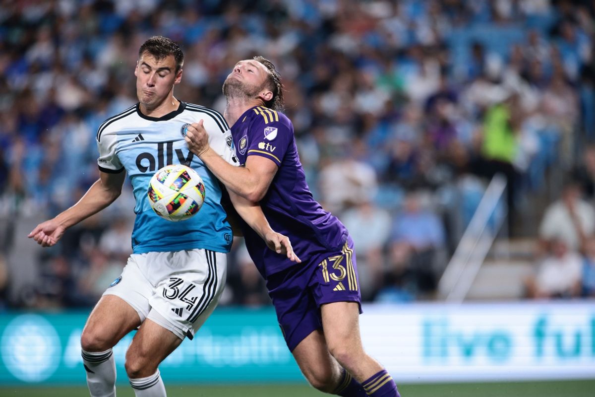 Nov 1, 2024; Charlotte, North Carolina, USA;  Charlotte FC midfielder Andrew Privett (34) battles for the ball against Orlando City forward Duncan McGuire (13) during the second half at Bank of America Stadium. Mandatory Credit: Scott Kinser-Imagn Images