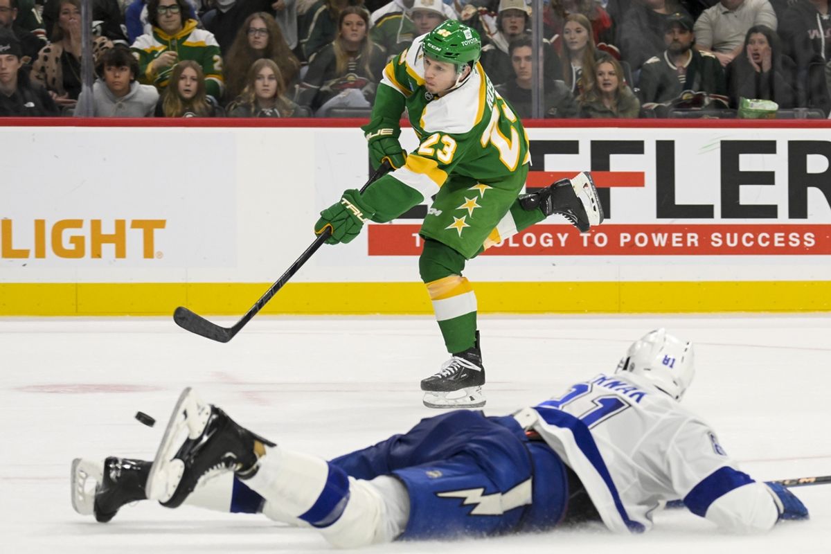 Nov 1, 2024; Saint Paul, Minnesota, USA;  Minnesota Wild forward Marco Rossi (23) takes a shot on goal as Tampa Bay Lightning defenseman Erik Cernak (81) lays out in an attempt to block it during the second period at Xcel Energy Center. Mandatory Credit: Nick Wosika-Imagn Images