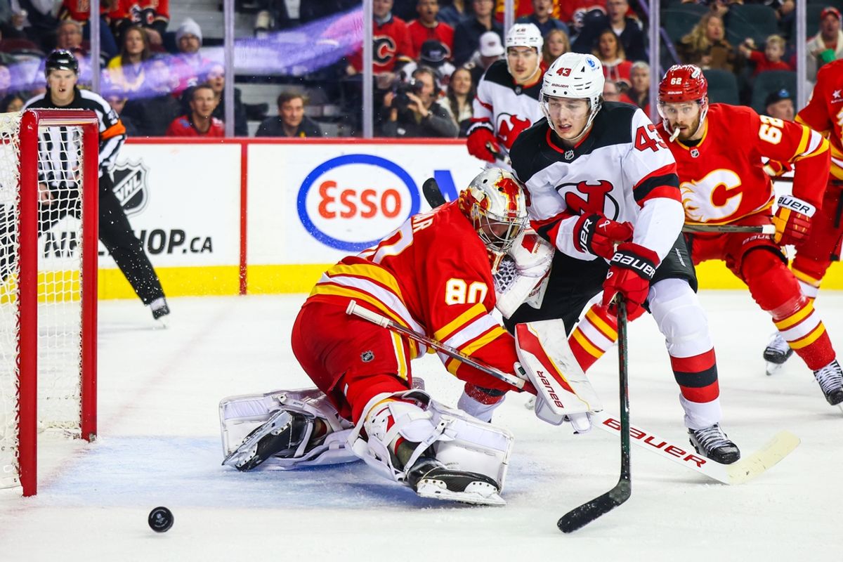 Nov 1, 2024; Calgary, Alberta, CAN; Calgary Flames goaltender Dan Vladar (80) makes a save against New Jersey Devils defenseman Luke Hughes (43) during the first period at Scotiabank Saddledome. Mandatory Credit: Sergei Belski-Imagn Images