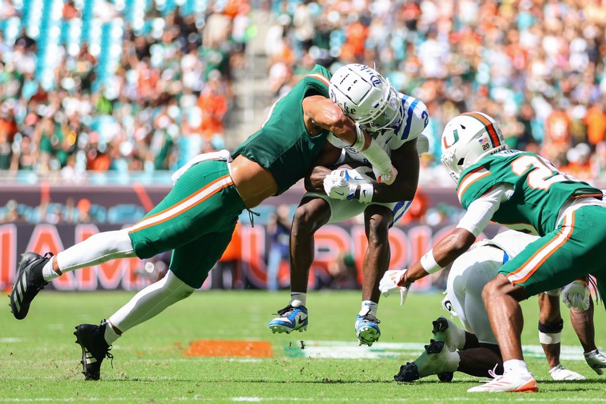 Nov 2, 2024; Miami Gardens, Florida, USA; Duke Blue Devils wide receiver Sahmir Hagans (2) is tackled by Miami Hurricanes linebacker Francisco Mauigoa (1) during the second quarter at Hard Rock Stadium. Mandatory Credit: Sam Navarro-Imagn Images