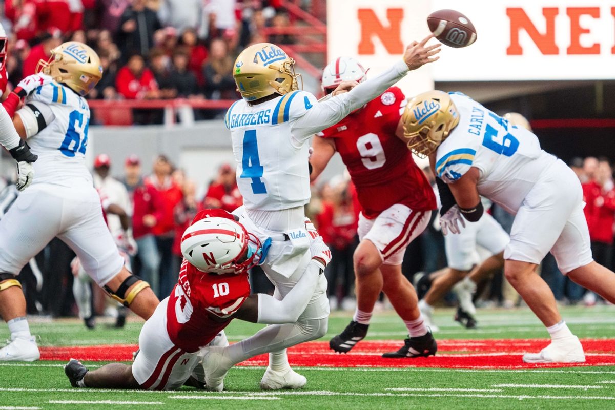 Nov 2, 2024; Lincoln, Nebraska, USA; UCLA Bruins quarterback Ethan Garbers (4) throws as he is hit by Nebraska Cornhuskers defensive lineman Jimari Butler (10) during the second quarter at Memorial Stadium. Mandatory Credit: Dylan Widger-Imagn Images