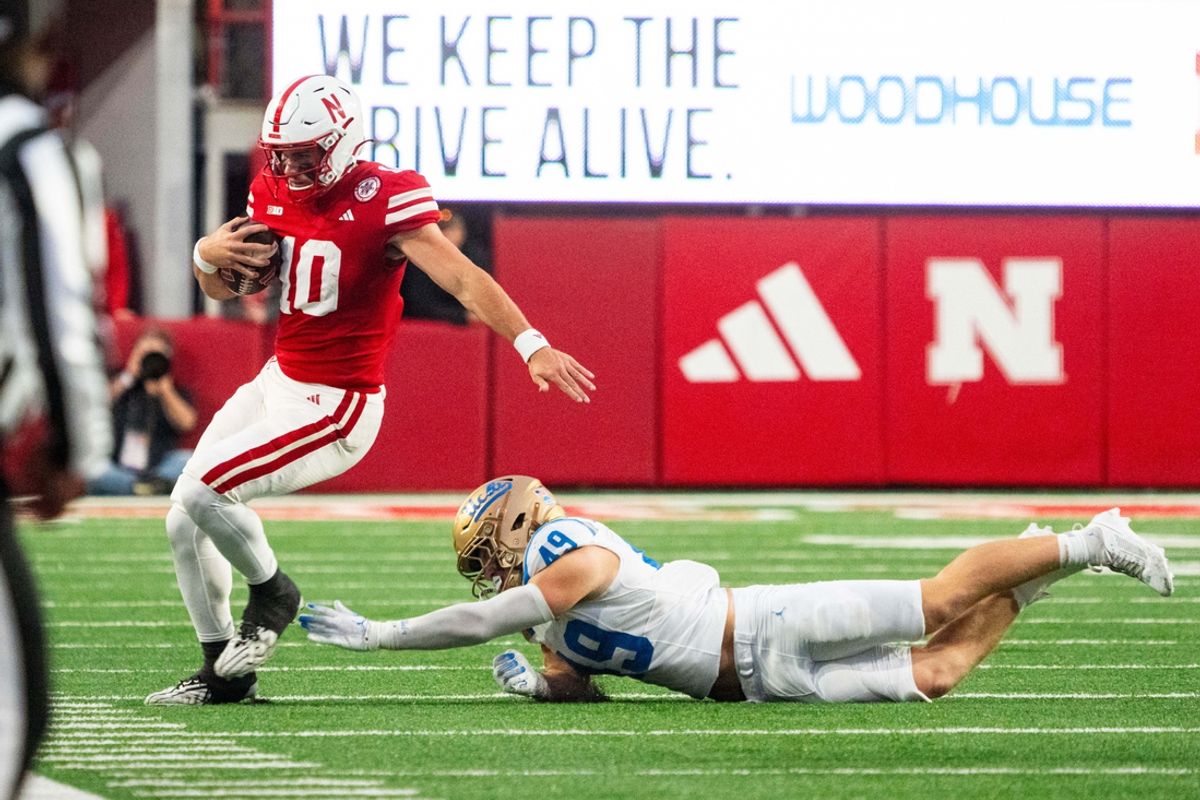 Nov 2, 2024; Lincoln, Nebraska, USA; Nebraska Cornhuskers quarterback Heinrich Haarberg (10) runs out of bounds against UCLA Bruins linebacker Carson Schwesinger (49) during the fourth quarter at Memorial Stadium. Mandatory Credit: Dylan Widger-Imagn Images