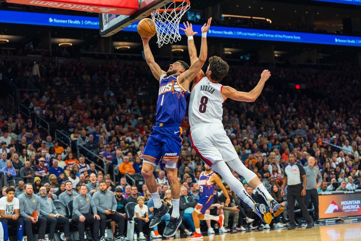 Nov 2, 2024; Phoenix, Arizona, USA;  Phoenix Suns guard Devin Booker (1) drives past Portland Trail Blazers forward Deni Avdija (8) in the first half during a game at Footprint Center. Mandatory Credit: Allan Henry-Imagn Images